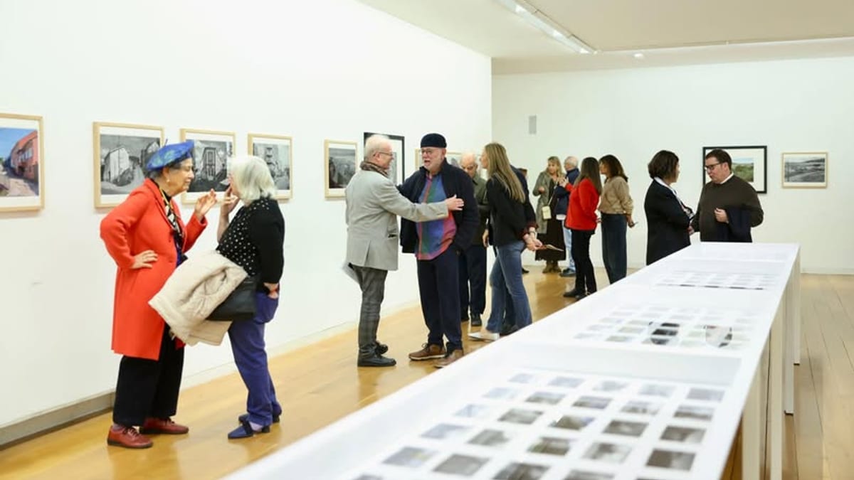 Galería de arte con visitantes observando fotografías de la exposición Galicia Urbana en el CGAC