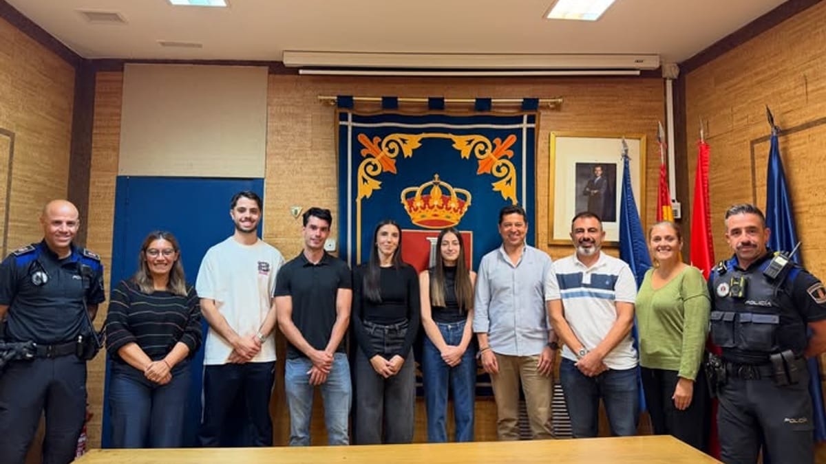Grupo de nuevos agentes en prácticas de Policía Local de Humanes de Madrid posando en una sala oficial con heráldica y banderas de fondo