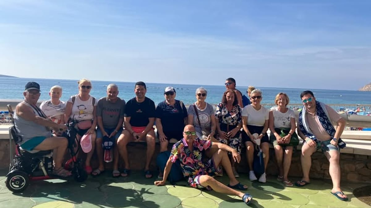 Grupo de mayores disfrutando de una escapada en Benidorm con vistas al mar y ambiente festivo