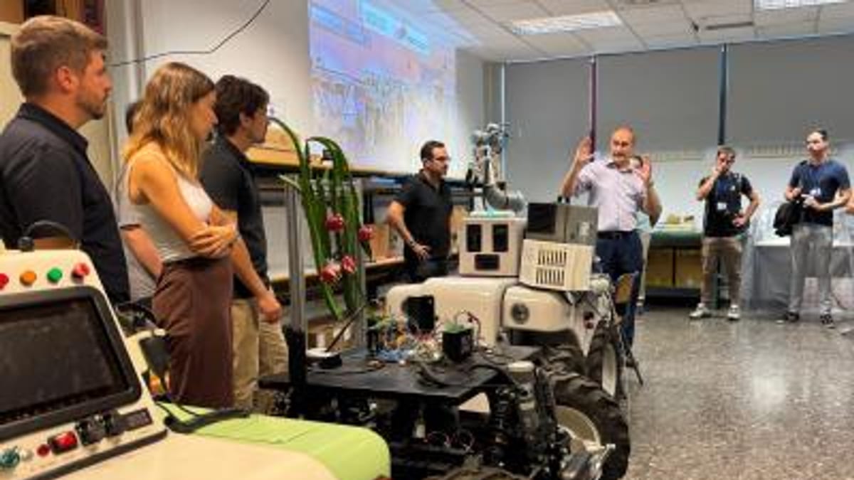 Grupo de investigadores observando un robot o máquina en un laboratorio durante una demostración de proyecto de innovación