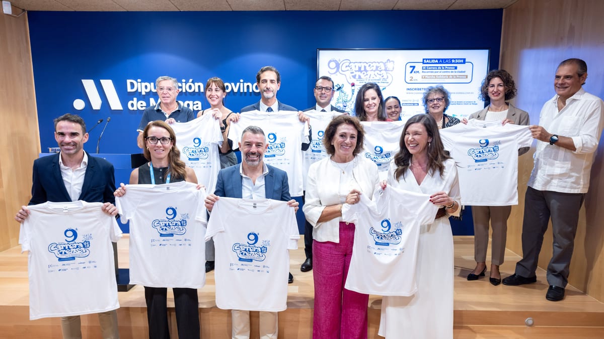 Presentación de la IX Carrera de la Prensa y V Marcha Solidaria en la Diputación de Málaga con participantes mostrando las camisetas de la prueba