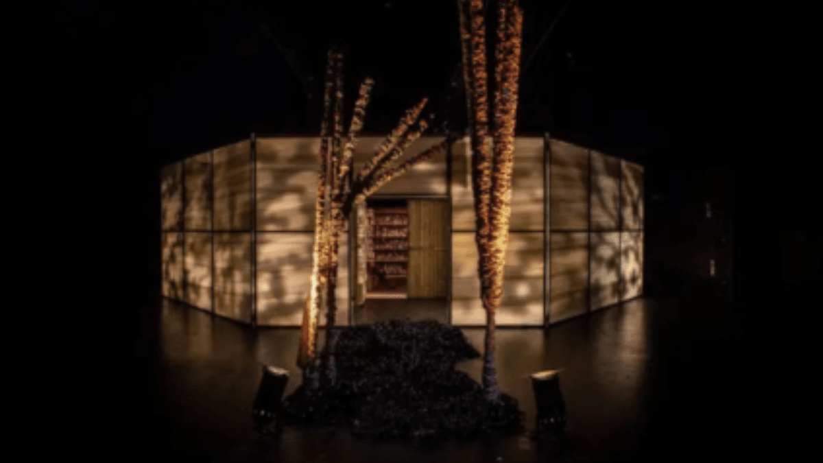 Instalación artística inmersiva con estructura iluminada de forma circular, plantas decoradas y fondo oscuro, representativa del trabajo creativo de José Antonio Portillo