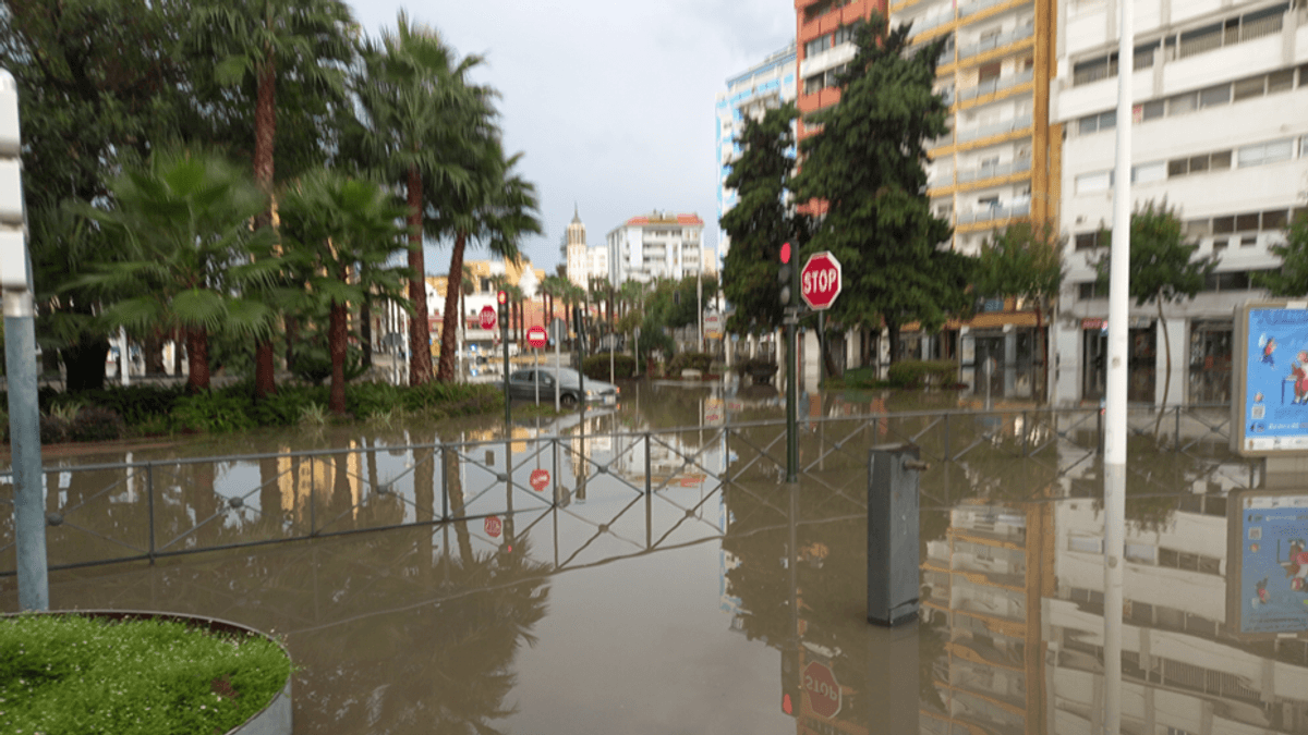 Zona urbana inundada con edificios y palmeras afectados por el temporal en Andalucía