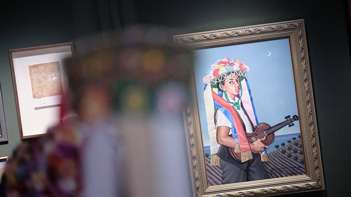 Cuadro enmarcado en el MUCAC que muestra una figura con atuendo tradicional sosteniendo un instrumento musical, parte de la exposición sobre los Verdiales de Málaga