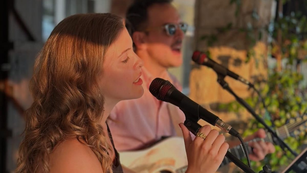 Palmira Yelo cantando con micrófono durante una actuación musical