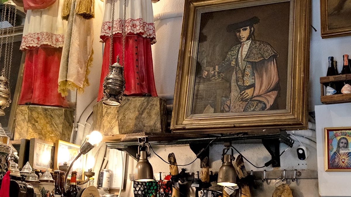 Interior de la taberna Los Gatos en el Barrio de las Letras con decoración vintage, objetos antiguos en paredes y techos