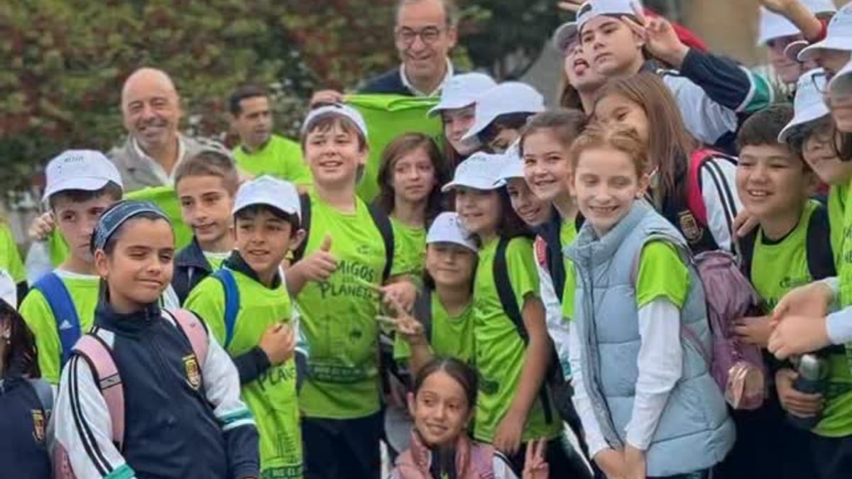 Grupo de niños y adultos en actividad escolar vistiendo chalecos y camisetas de color verde neón durante la Marcha Ecológica del Colegio María Auxiliadora en el Parque del Rodeo