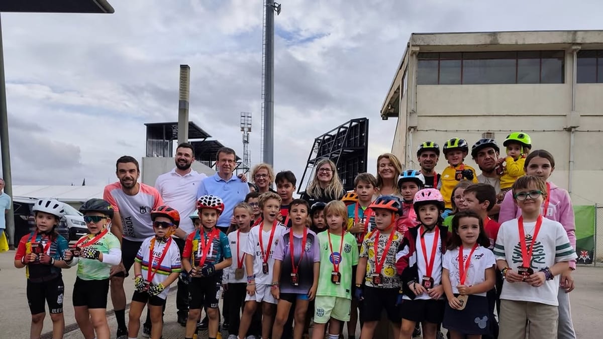 Grupo de niños y adultos en el evento de la Marcha Popular by amiab en Cuenca, portando cascos y medallas tras participar en el circuito infantil de ciclismo