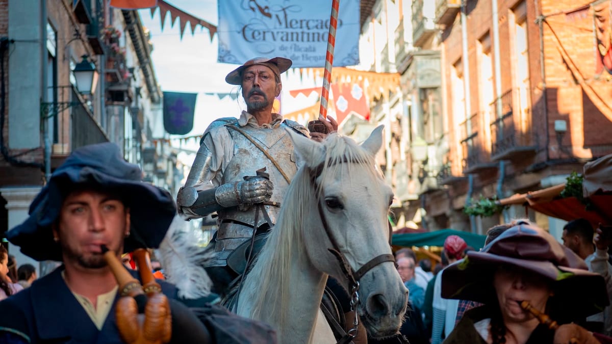 Bandera y escenografía del Mercado Cervantino en una calle histórica de Alcalá de Henares durante la Semana Cervantina