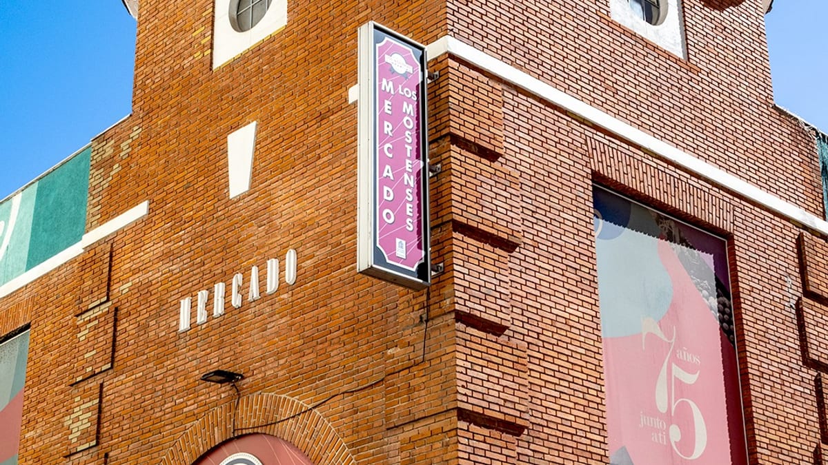 Fachada del Mercado de los Mostenses en Madrid con señalización visible de entrada y ubicación en calle Ricardo León