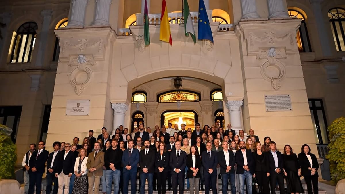 Grupo de concejales y el alcalde de Málaga guardando un minuto de silencio en la escalinata del Ayuntamiento
