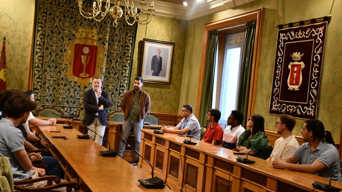 Reunión entre autoridades de Cuenca y alumnado del máster de Ingeniería de Caminos de la UCLM en una sala de juntas municipal