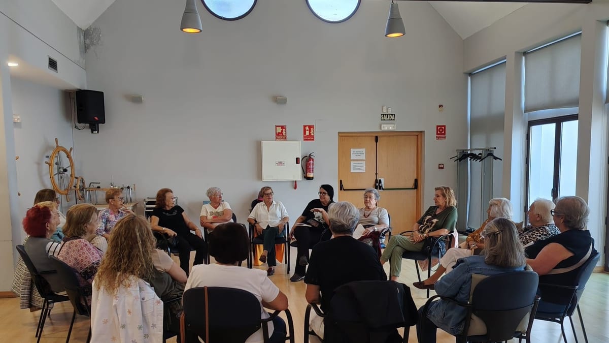 Grupo de mayores participantes en el taller de teatro de Navalcarnero sentados en círculo en una sala