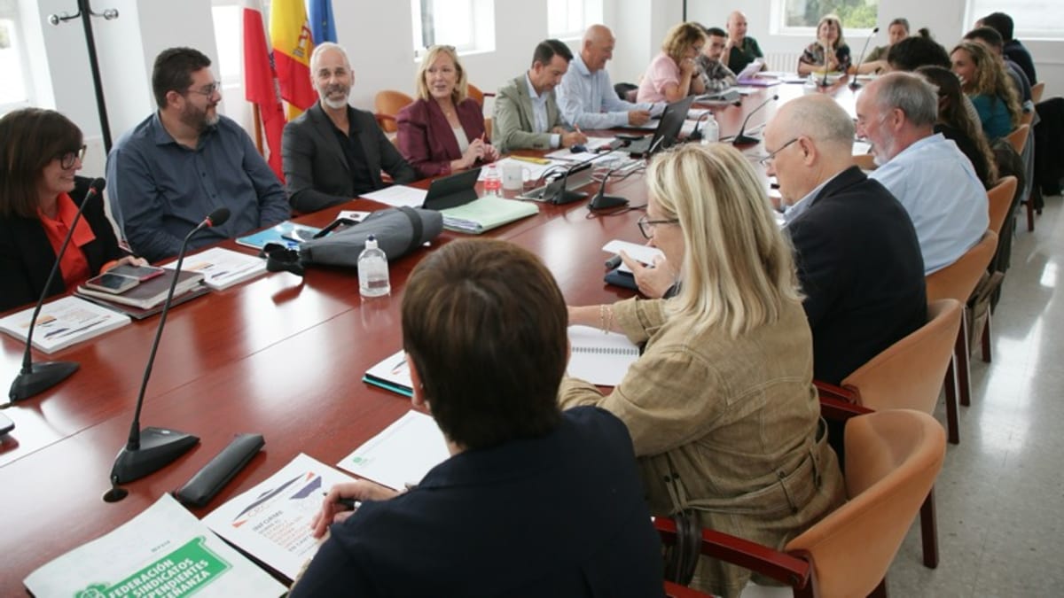 Reunión del Consejo Escolar de Cantabria en sala de conferencias con múltiples participantes alrededor de una mesa larga