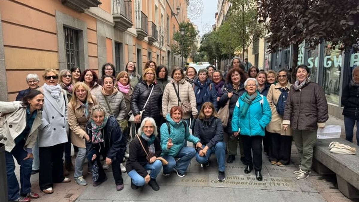 Grupo de participantes en el paseo cultural sobre Emilia Pardo Bazán posando en una calle del centro de Madrid con edificios históricos de fondo