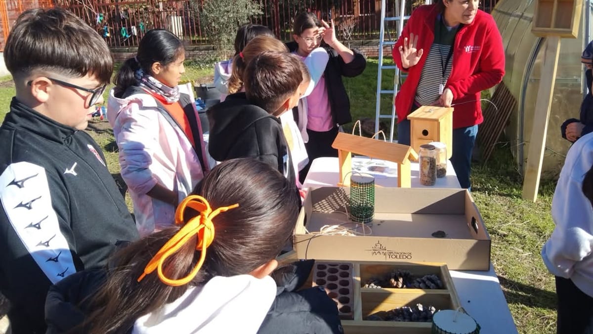 Actividad educativa de Patios Vivos con niños y una instructora realizando labores de jardinería en un espacio verde de un centro educativo