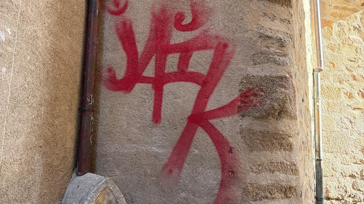 Graffiti en rojo en una pared de piedra de la Ciudad Monumental de Cáceres