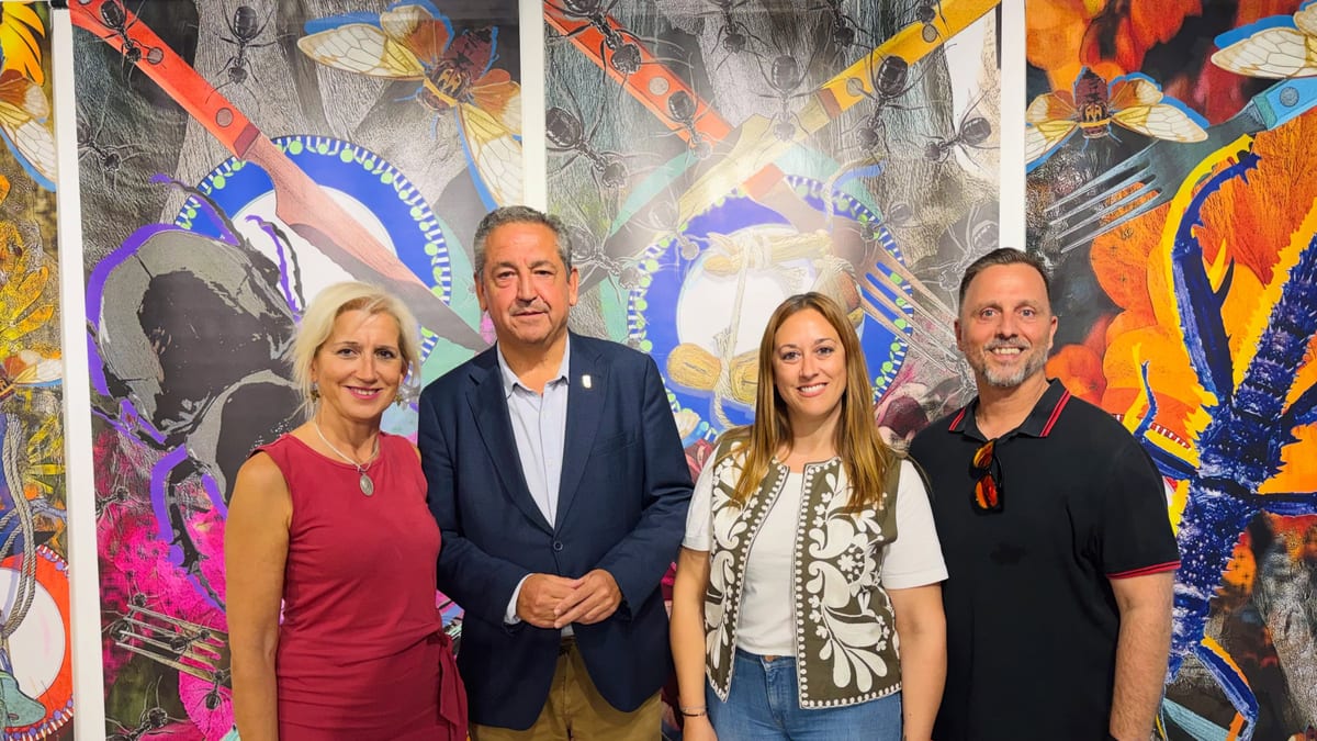 Personas posando ante mural de arte con diseños geométricos e insectos en la inauguración de PintoArte 2026