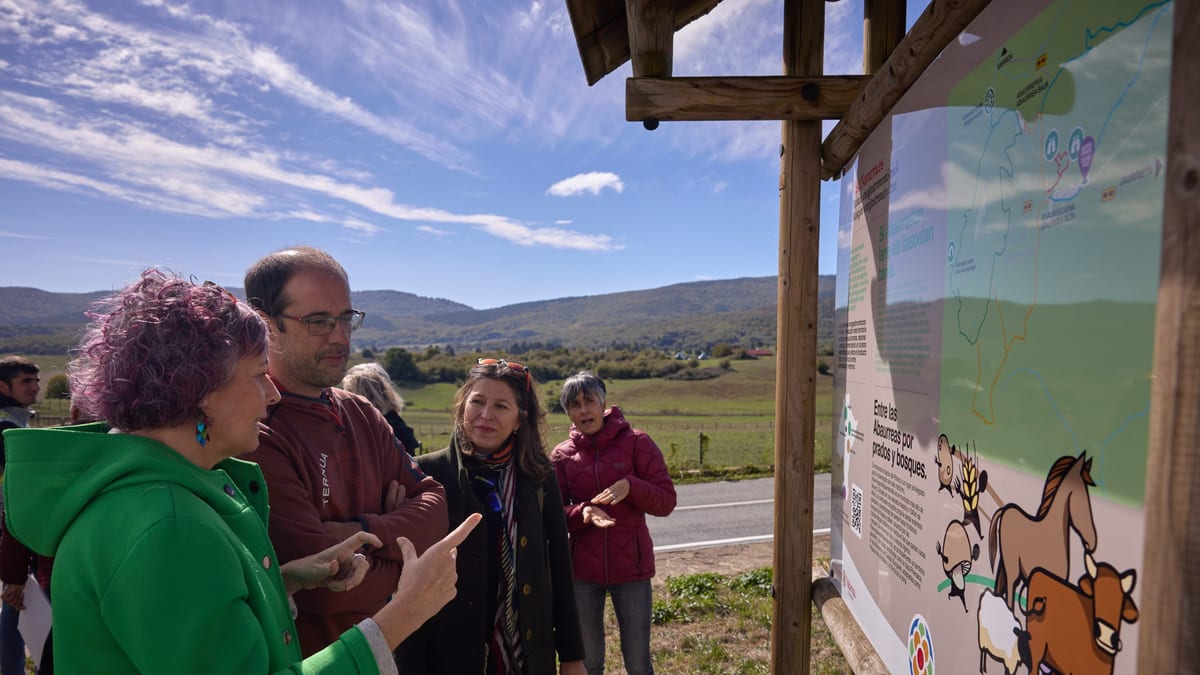 Grupo de personas observando un cartel informativo sobre el Plan de Sostenibilidad Turística en Destino en el Pirineo navarro