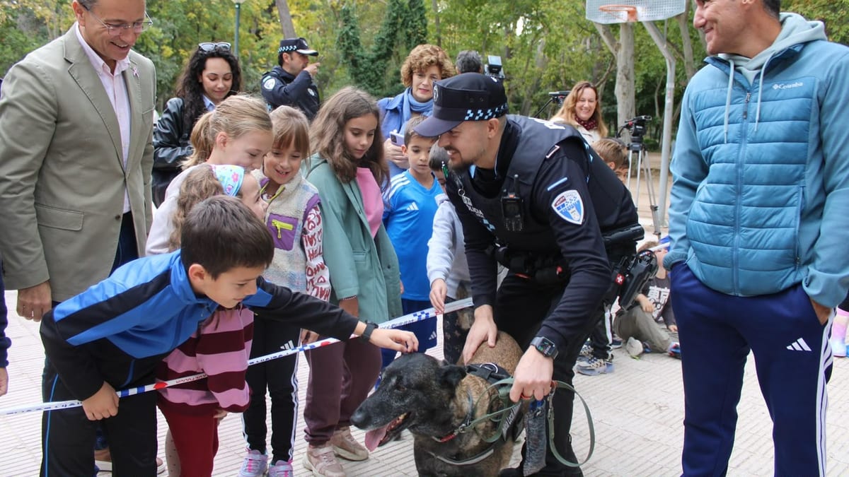 Policía local de Albacete con perro de trabajo interactuando con niños en el Parque Abelardo Sánchez durante la presentación de la nueva Unidad Canina