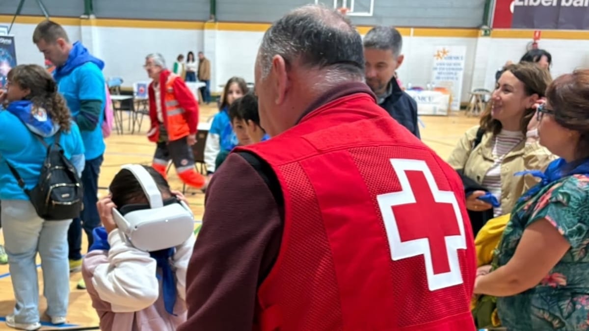 Voluntario de la Cruz Roja interactuando con participantes en la Jornada de Convivencia del pabellón Fuente del Oro de Cuenca