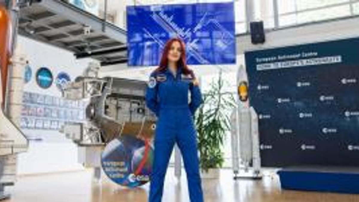 Sara García, astronauta española, en traje de astronauta en un centro espacial con modelo de transbordador