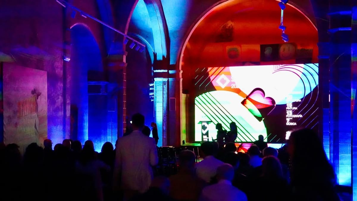 Escena de la ceremonia de los Premios Ciudad Badajoz 2026 en el Espacio Cultural Santa Catalina con iluminación de neón y pantalla de proyección