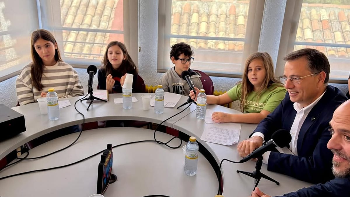 Manuel Serrano, alcalde de Albacete, durante la inauguración de Radio Tiza en el Colegio Carlos V, rodeado de docentes y alumnos en la mesa de emisión