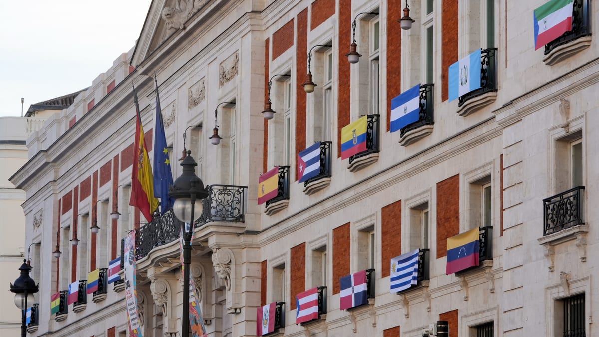 Fachada de la Real Casa de Correos con las banderas de los 22 países hispanohablantes y Estados Unidos para la celebración de Hispanidad 2026