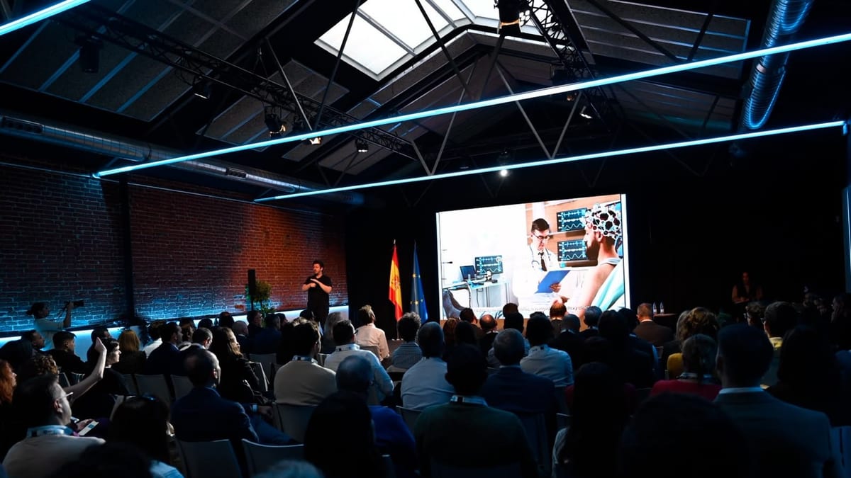 Jornada técnica de Red.es sobre proyectos de inteligencia artificial en salud en Madrid con participantes, pantalla de presentación y banderas