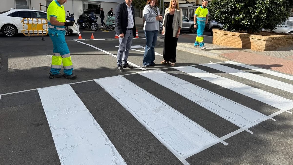 Operarios realizan trabajos de repintado en un paso de peatones de Huelva