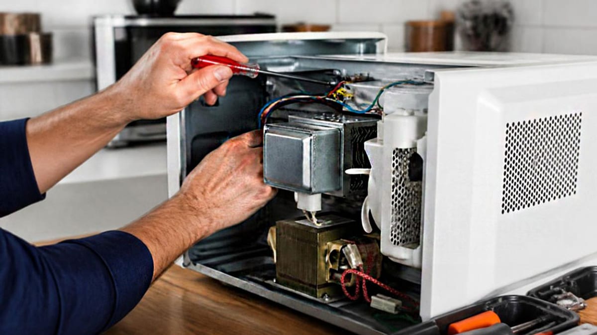 Técnico reparando el interior de un electrodoméstico, ilustración del derecho a reparación gratuita en garantía