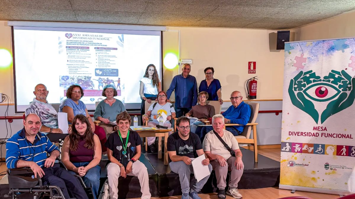 Inauguración de las XXXI Jornadas de Diversidad Funcional en San Fernando de Henares con el alcalde Javier Corpa y la edil Guadalupe Piñas. Cartel de la mesa de Diversidad Funcional visible al fondo.