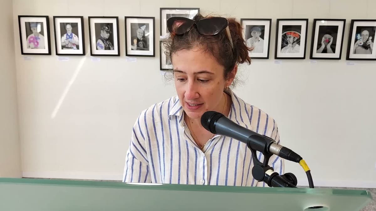 Mujer en el podio con micrófono durante la celebración del Día de las Escritoras en la biblioteca Marcos Ana de San Sebastián de los Reyes