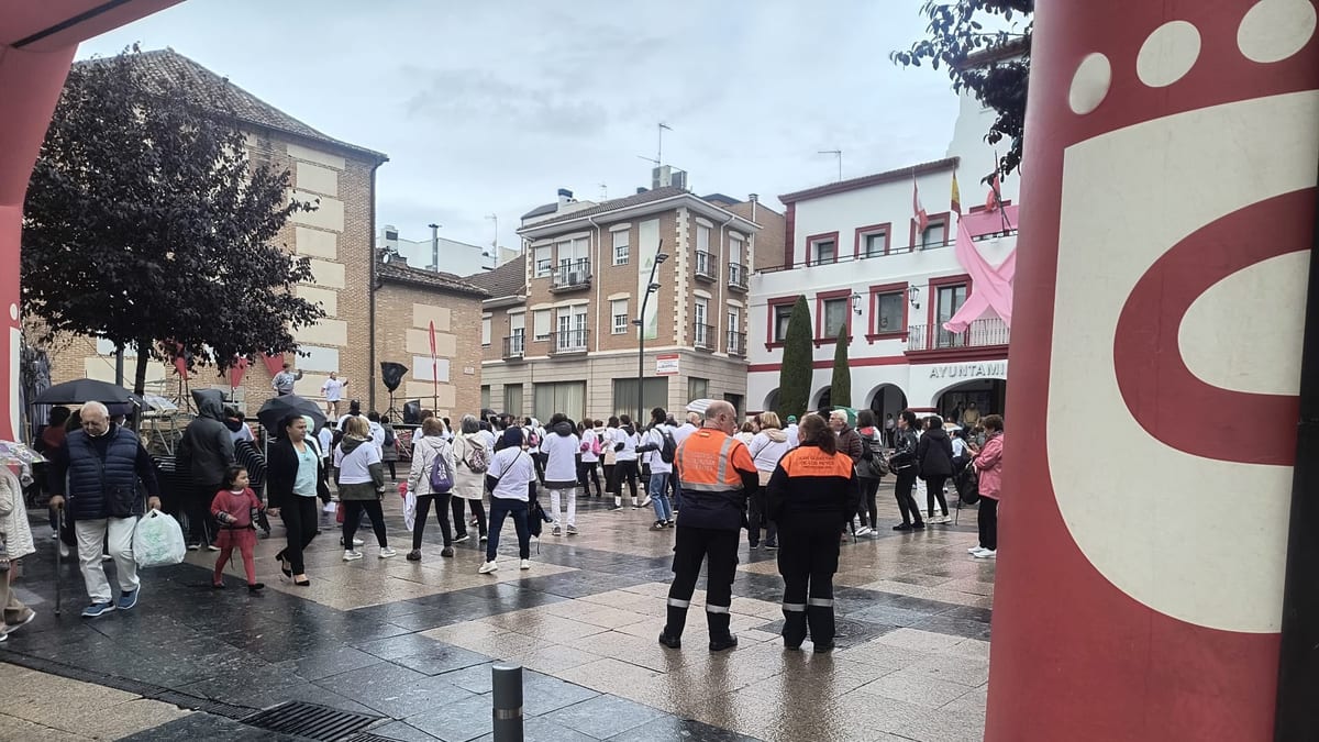 Participantes en la II Marcha contra el Cáncer de Mama en San Sebastián de los Reyes, con edificios municipales de fondo