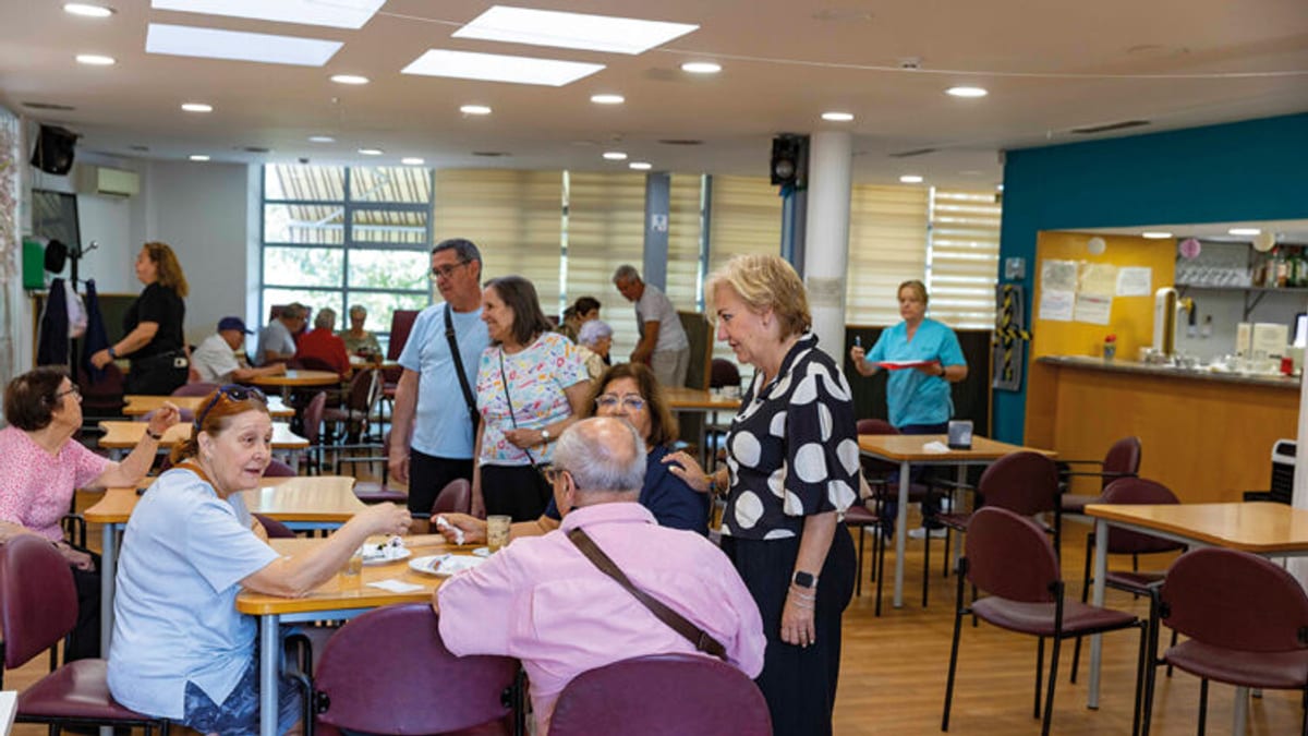 Cafetería de un centro de mayores con personas participando en actividades