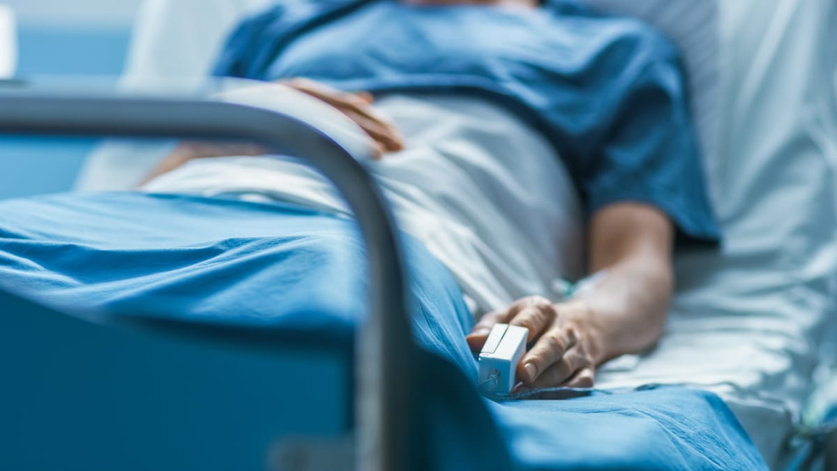 Paciente en cama de hospital recibiendo atención médica