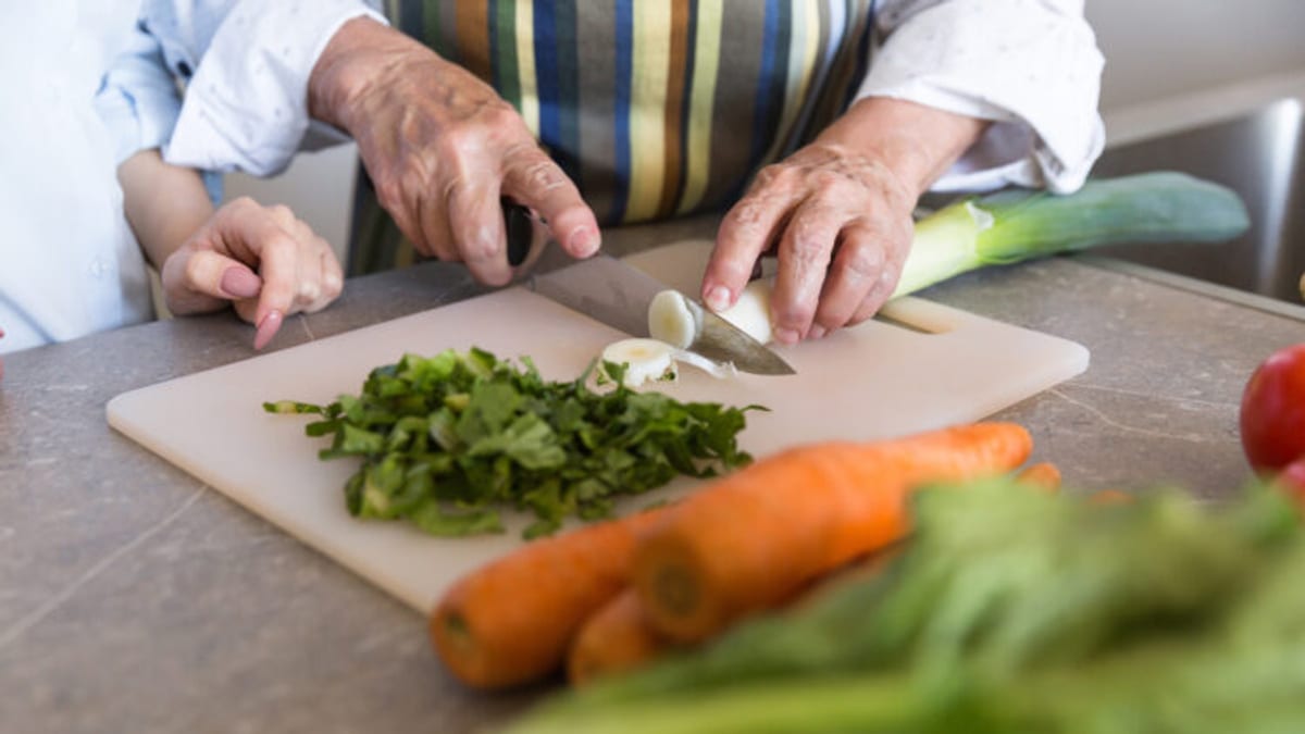 Persona mayor cocinando en un taller de alimentación