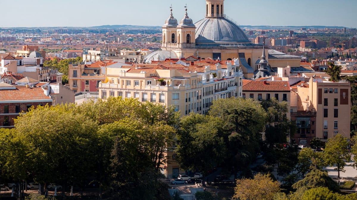 Vista aérea de los tejados de Madrid contra un cielo azul, mostrando la arquitectura urbana de la capital