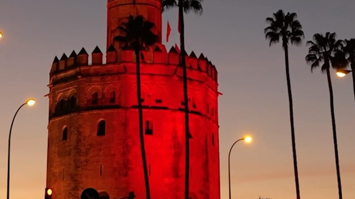 Torre del Oro y Muralla de la Macarena iluminadas con los colores rojo y amarillo de la bandera española en el Día de la Hispanidad