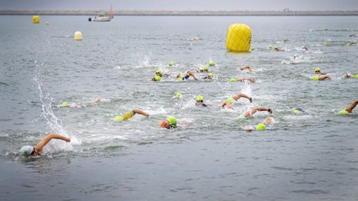 Triatletas compitiendo en la quinta edición del Triatlón Playas de Mazagón en el puerto deportivo
