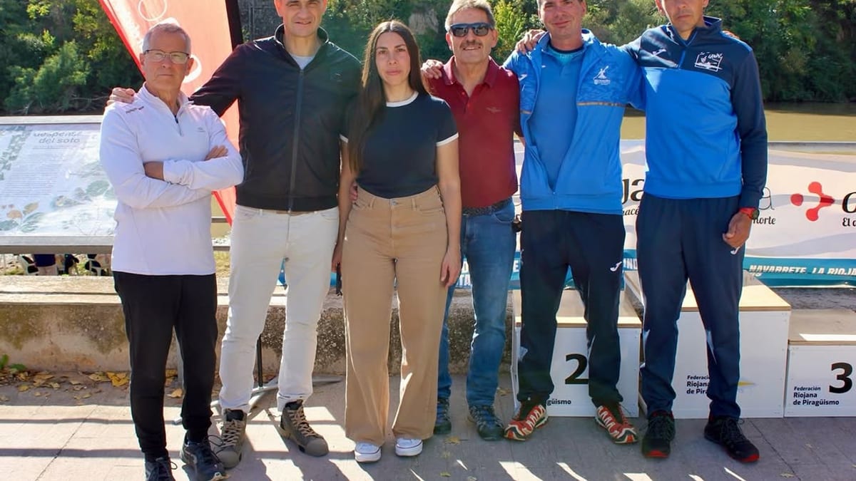 Seis deportistas posando frente a un podio de competición junto al río Ebro durante el Trofeo de San Gregorio de Piragüismo de Logroño