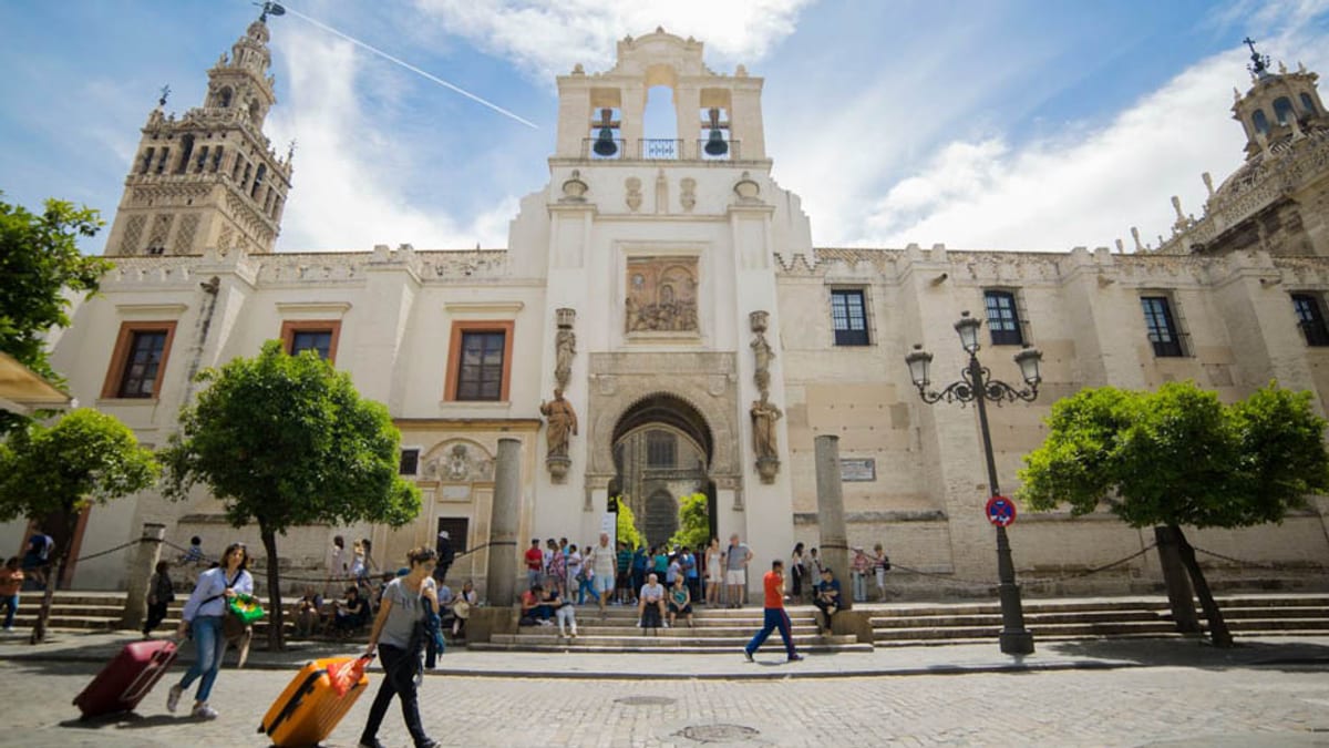 Plaza España de Sevilla con turistas, maletas y arquitectura colonial