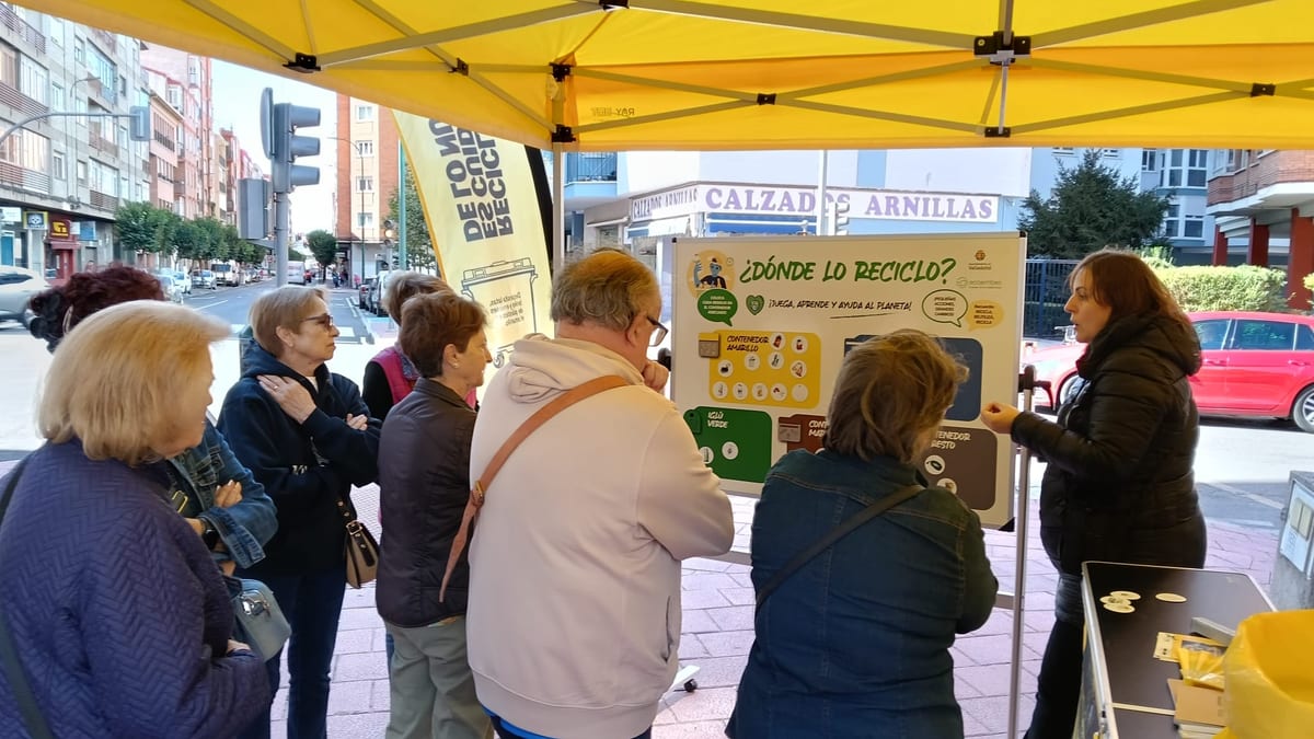 Punto informativo de la campaña de reciclaje de Ecoembes y Ayuntamiento de Valladolid en Paseo San Vicente, Barrio de Delicias, con educadores ambientales explicando la separación correcta de residuos