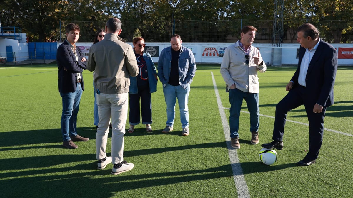 Grupo de hombres visitando el campo de fútbol 11 de Villaverde del Río con el nuevo césped artificial