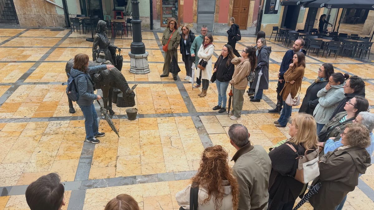 Grupo de personas participando en una visita guiada en la plaza de Oviedo durante el Día Mundial del Turismo