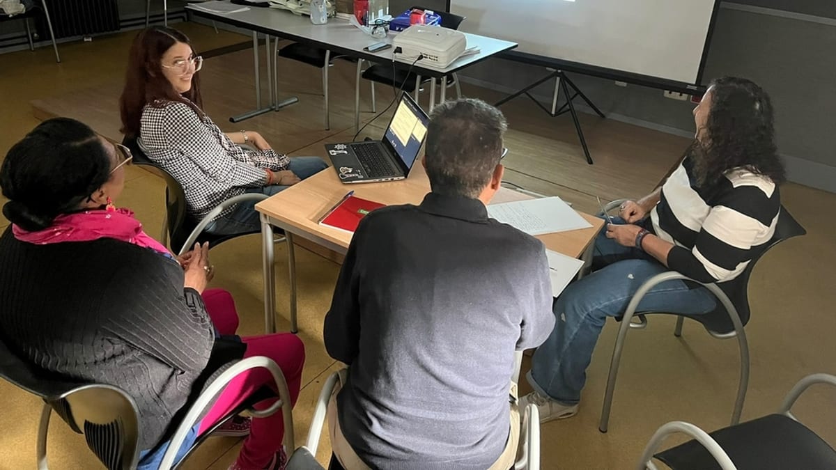 Reunión de formación del voluntariado de Cuenca en una sala de conferencias con proyector y materiales de trabajo