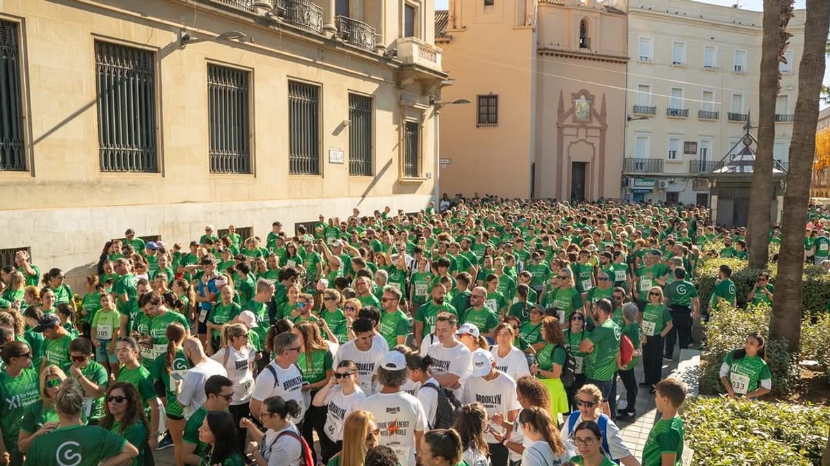 Participantes en la XI Marcha Contra el Cáncer de Huelva caminando por las calles con camisetas de la Asociación Española Contra el Cáncer